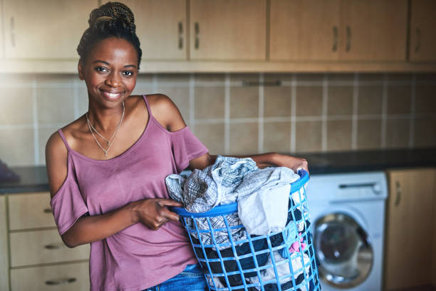 shot of a young woman doing laundry at home